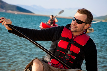 man wearing sunglasses kayaking on the water