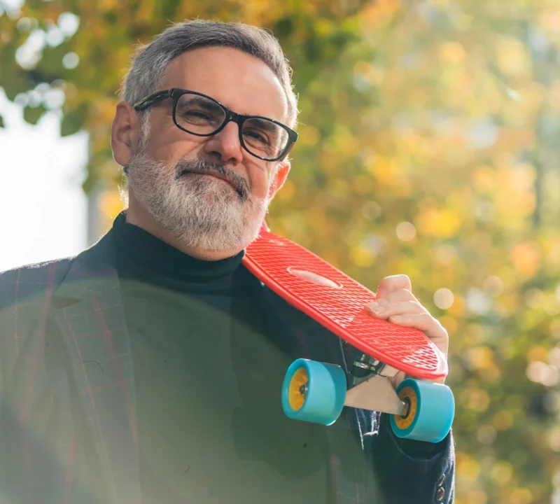 sports eyewear a mature man holding a skateboard wearing glasses