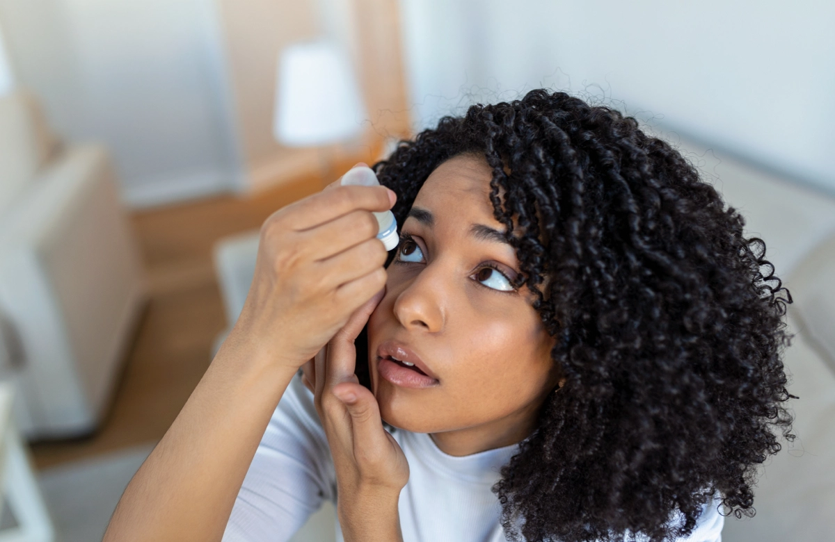 woman putting eyedrops in her eye